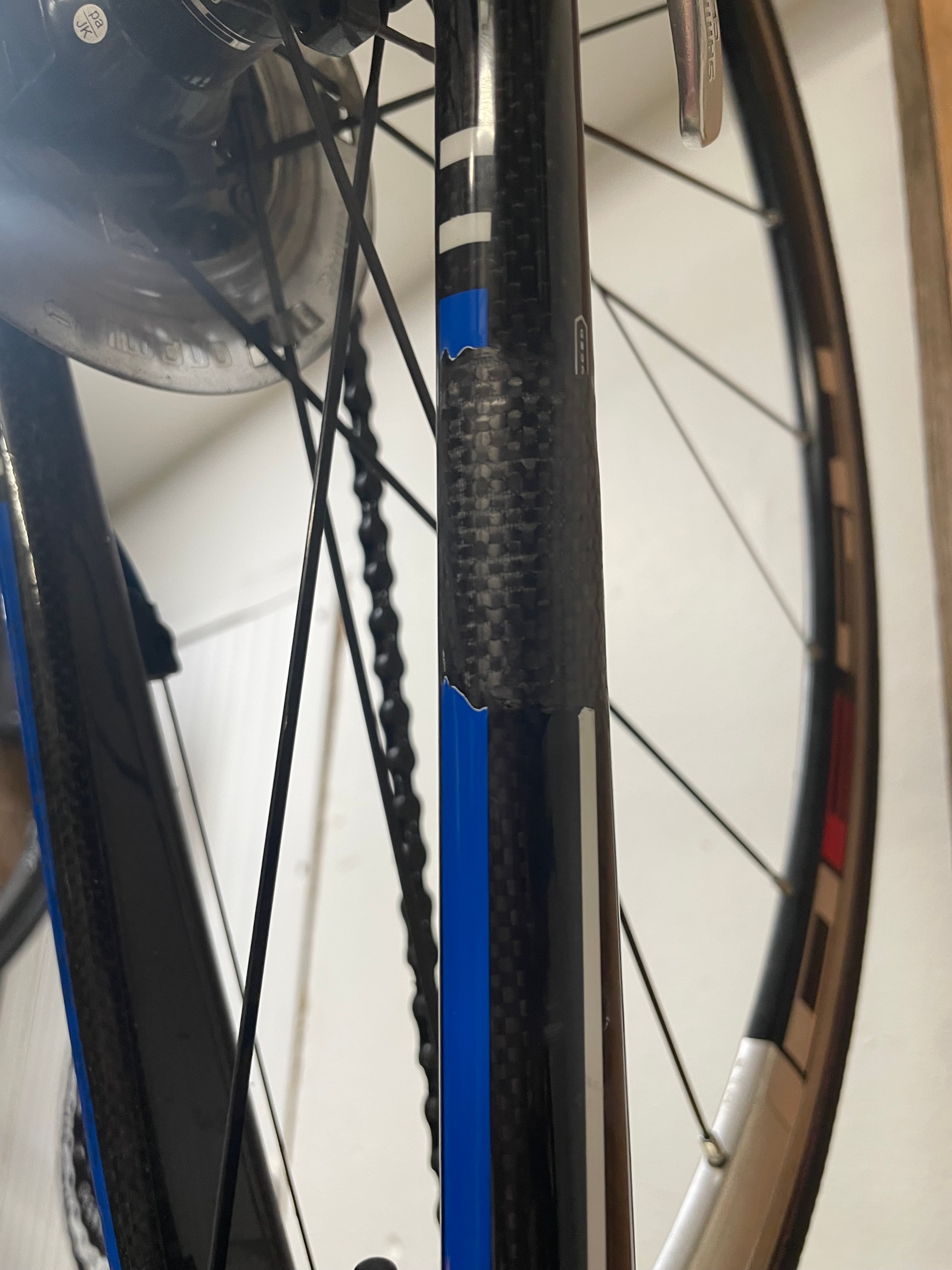 Carbon fiber seat stay repair detail — woven carbon patch blended into frame finish