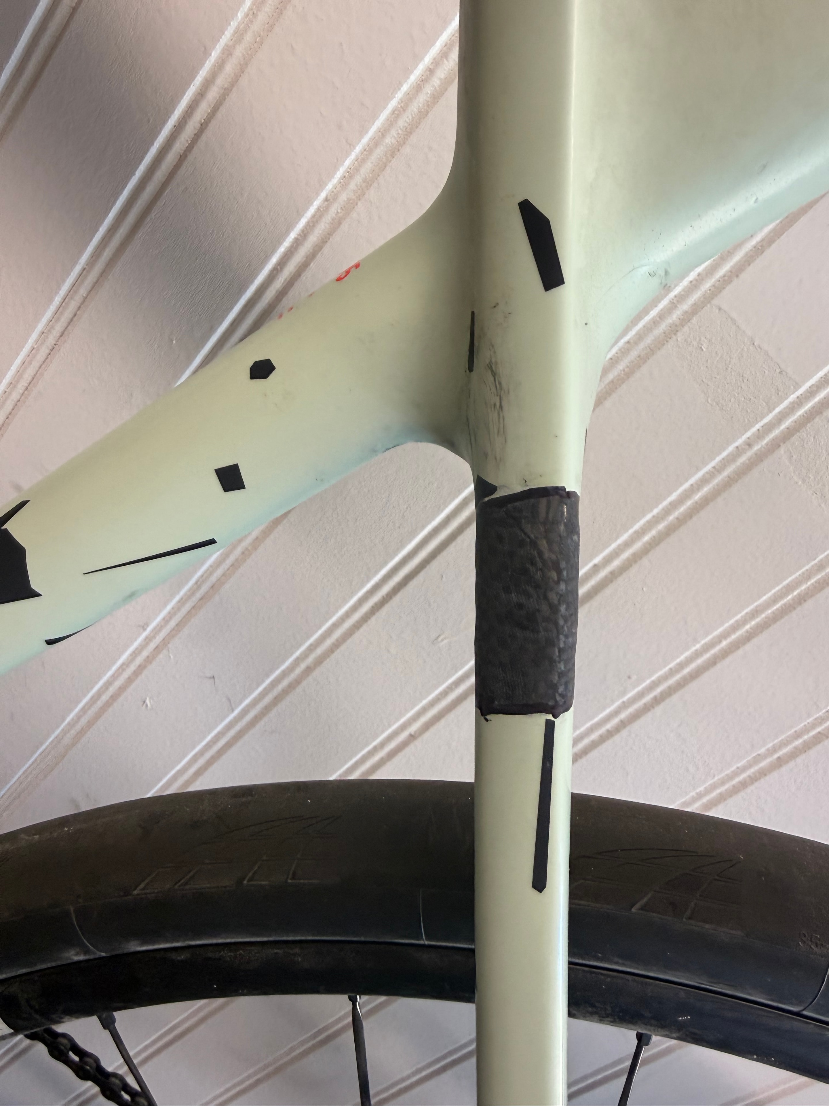 Carbon fiber seat stay repair detail showing woven carbon patch on bicycle frame