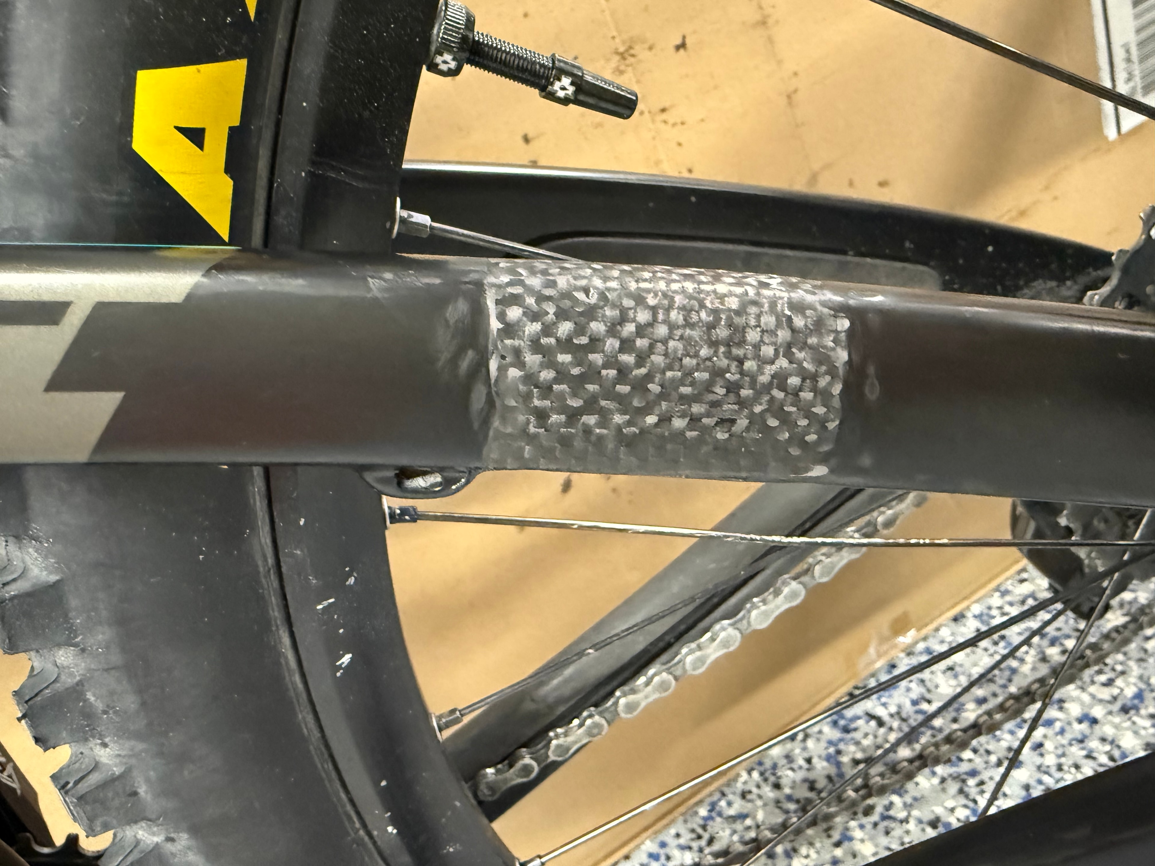 Carbon fiber bicycle seat stay repair showing finished woven carbon weave texture