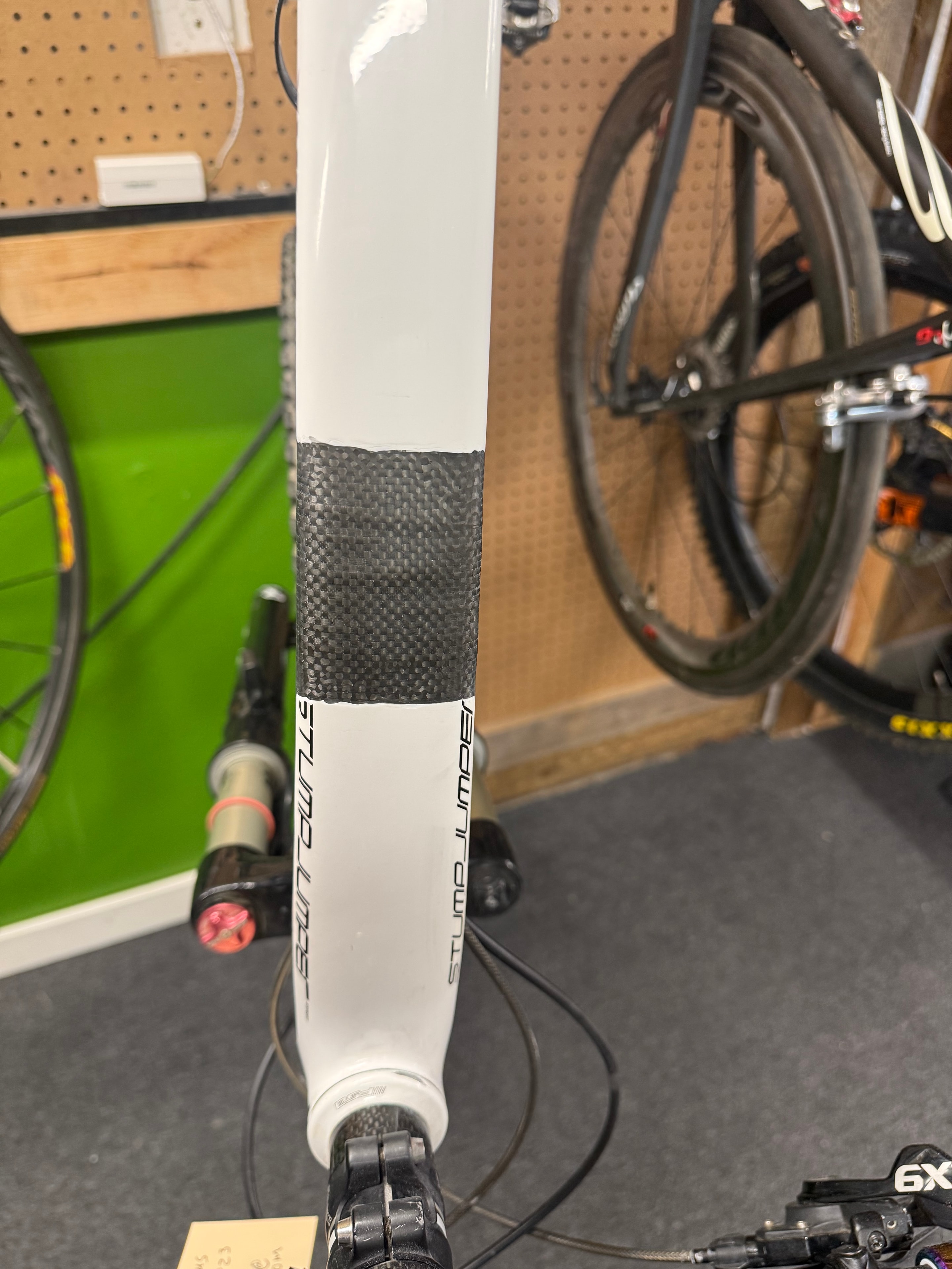 Carbon fiber top tube repair on a white Specialized Stumpjumper — close-up of woven patch